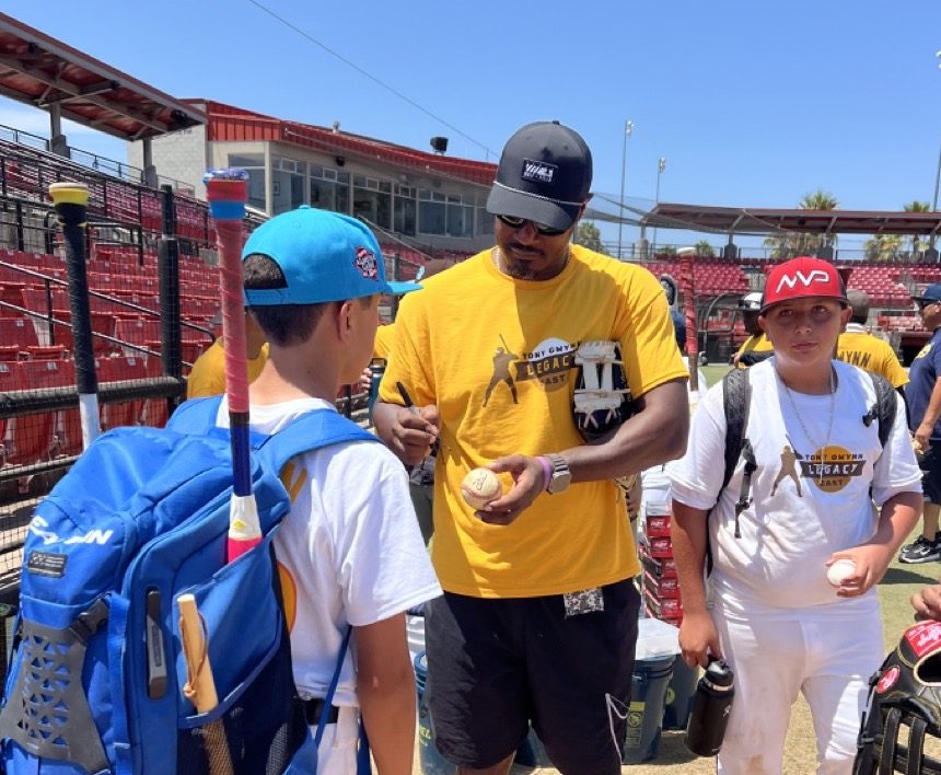 Adam Jones signing baseballs for young players